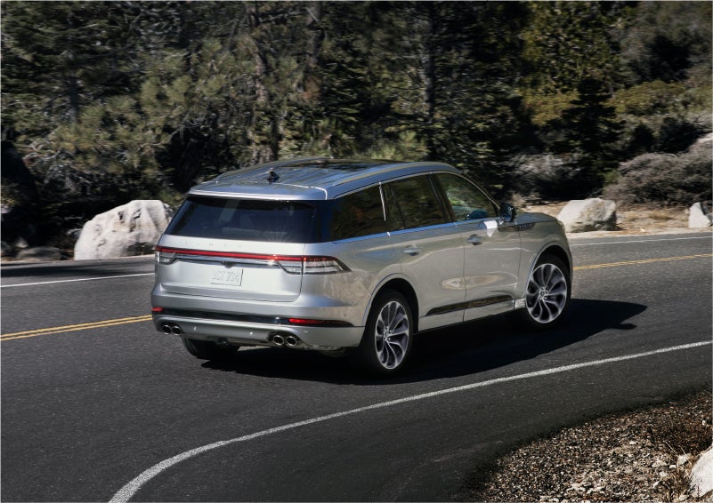 A 2023 Lincoln Aviator® Grand Touring model is shown being driven on a tight turn of a mountain road | All Star Lincoln in Prairieville LA