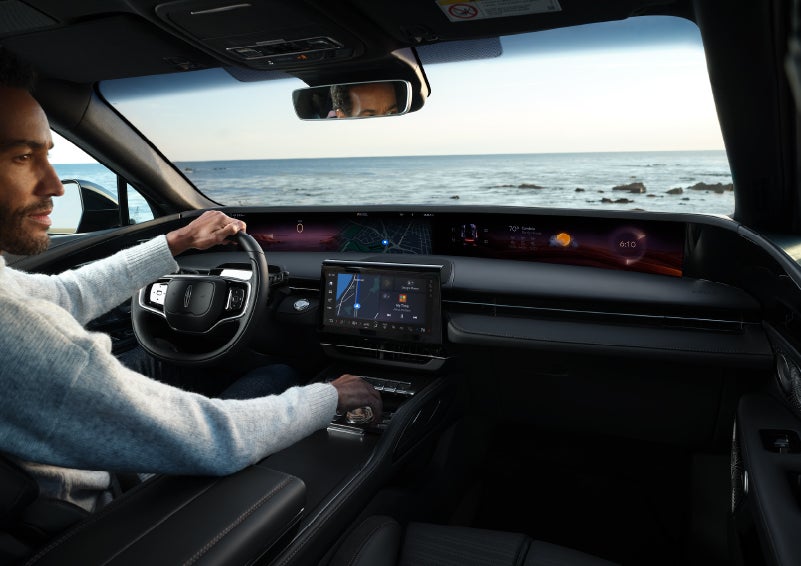 A driver of a parked 2024 Lincoln Nautilus® SUV takes a relaxing moment at a seaside overlook while inside his Nautilus. | All Star Lincoln in Prairieville LA